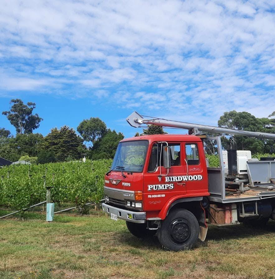 Birdwood Pumps red service truck on a rural property