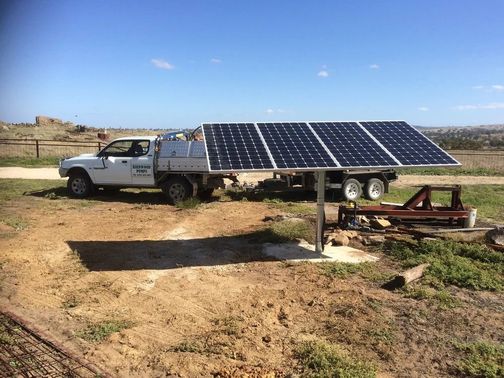 Ground-mounted solar panels powering a bore pump, with the Birdwood Pumps ute